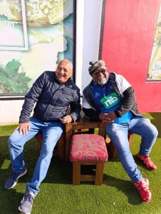 Two men laughing and relaxing together outdoors during a DBD Travel group tour